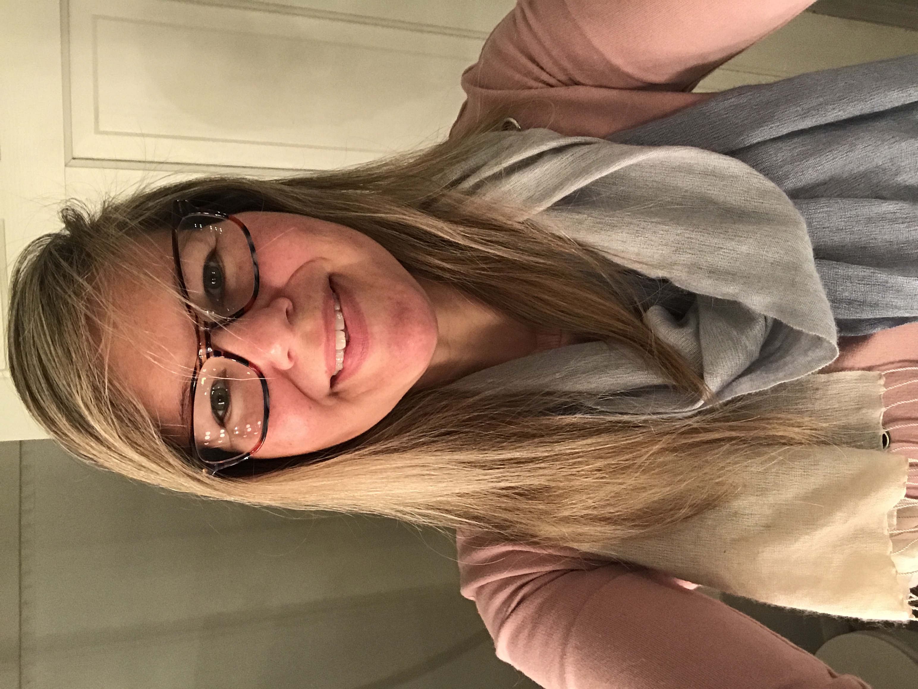 a person wearing glasses and smiling at the camera